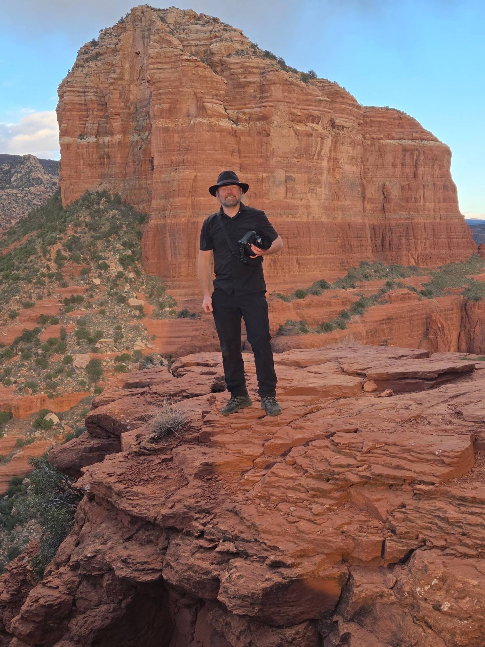 Ralph Kristopher with his camera on a red rock ledge in Sedona